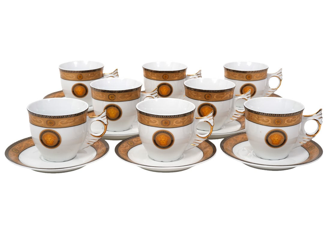 Versace Style Gold & White China Cups Saucers: Versace Style Gold & White China Cups Saucers includes 8 cups with wing style handles and Greek Key trim (4.25"W x 2 7/8"H; 8 matching saucers (5.75"W). Condition report: good condition, no issues, pl