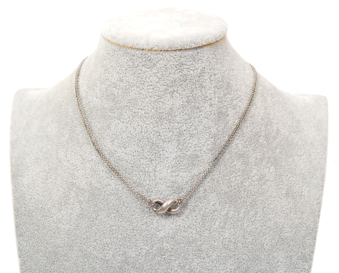 Tiffany & Co Infinity Sterling Pendent Necklace: Tiffany & Co infinity sterling silver pendent necklace. 15" long, weighs - 7.5g and is hallmarked on clasp. Condition report: Good condition, please examine all photos closely. Contact C. Biddle Aucti
