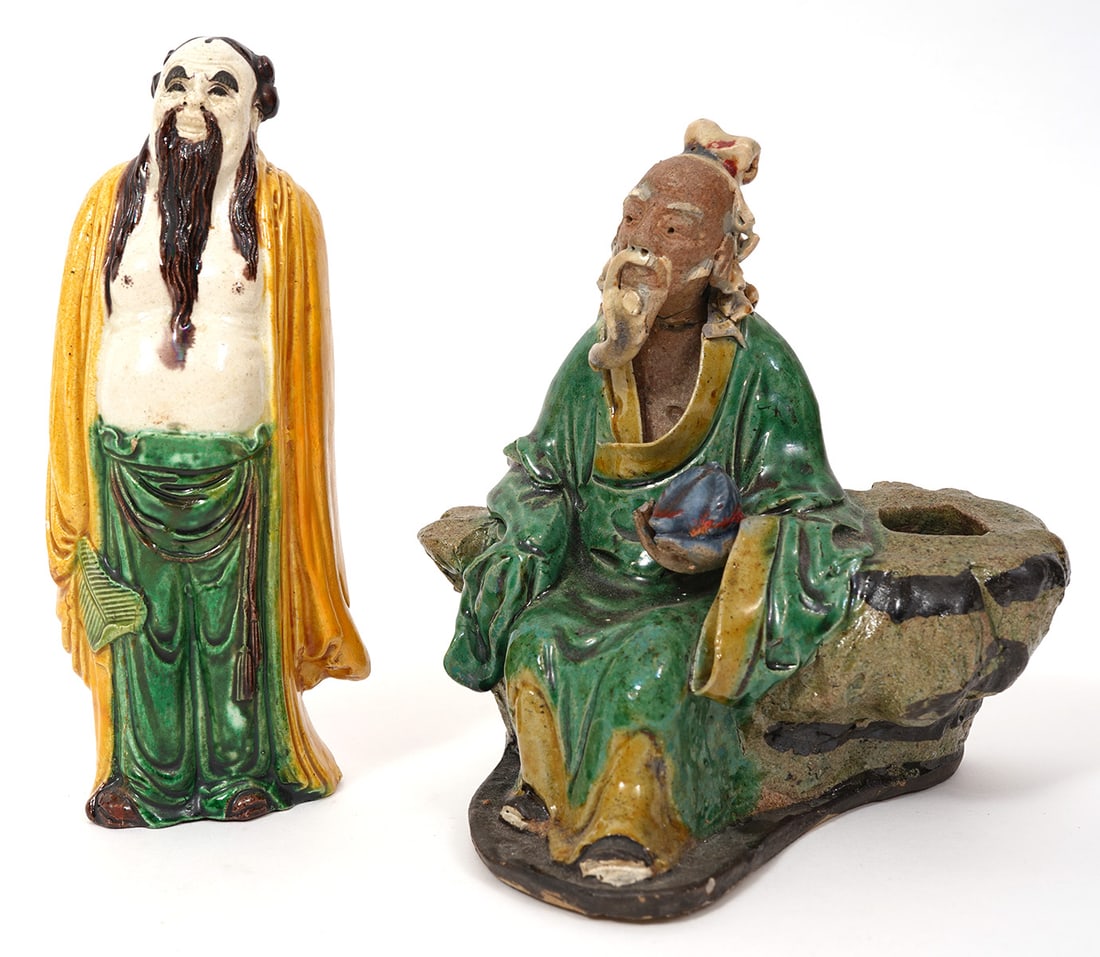 Two Chinese Mud Elder Figures: Two Chinese mud elder figures includes a standing figure (6.75"H x 2.5"H) and a seated figure holding fruit (6"H x 5.25"W). Condition report: Very minor chips, please examine all photos closely.