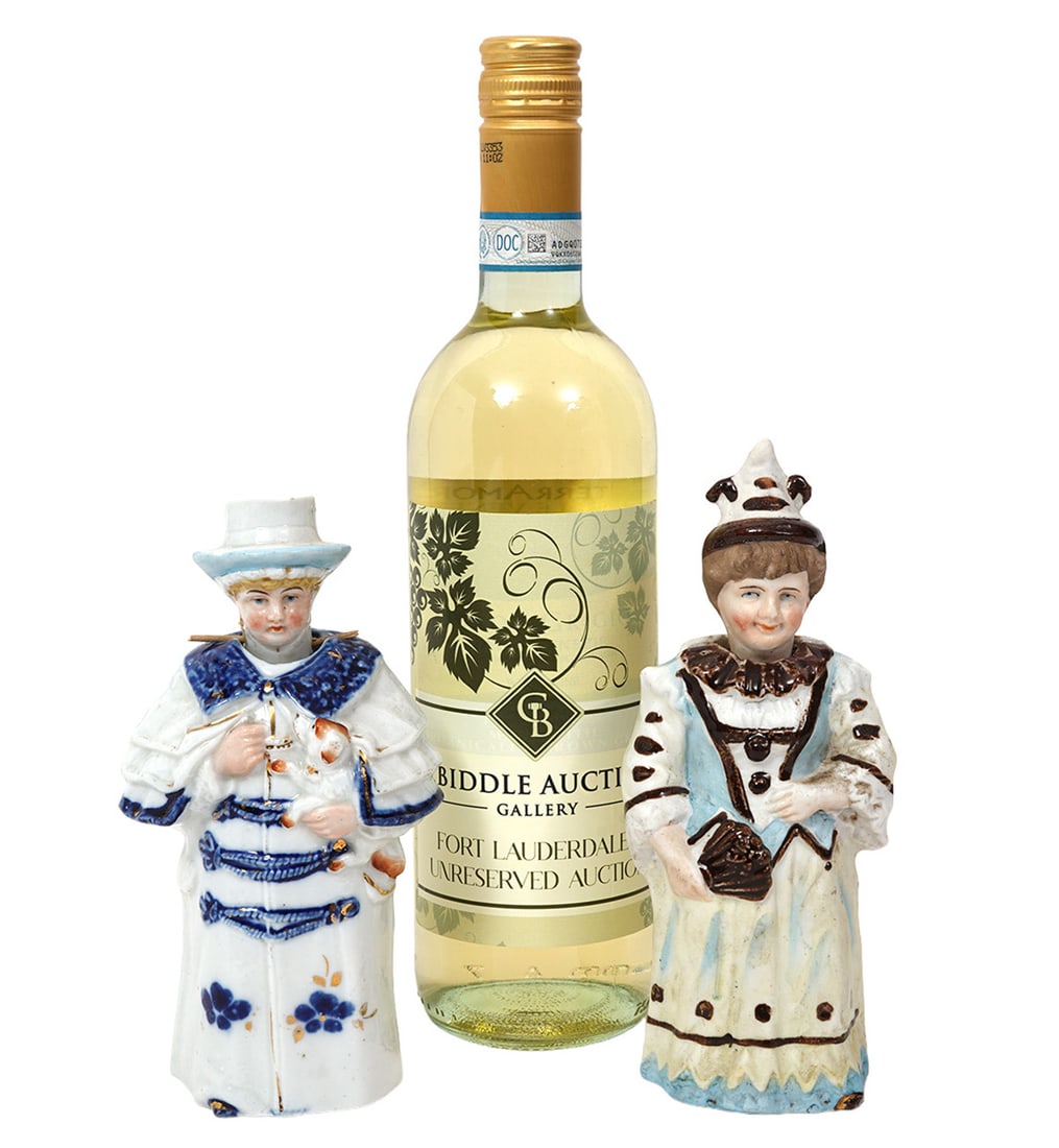 Two Continental Porcelain Nodders: Two Continental porcelain nodders includes a Blue and white glazed porcelain man holding a dog (7"H x 3.5"W); Costumed female in brown and white holding a fan (7.25"H x 3"W). Condition report: Good