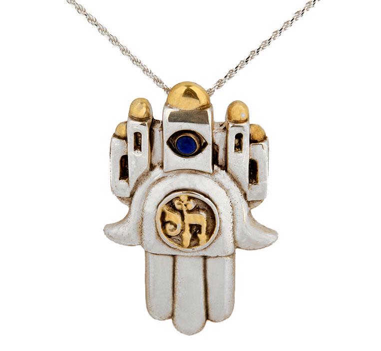 Frank Meisler, HAMSA HAI, PENDANT / PIN: H6.5 X W4 X L1.8 cm – 20gHamsa Hai Pendant and Pin. This Judaic good luck charm has an eye, made of Lapis lazuli, to ward off an evil eye. Silhouette of the walls of Jerusalem is found on top of the