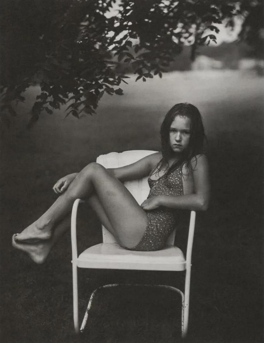 SALLY MANN - Juliet in White Chair, 1982: Photographer: Sally Mann is an American photographer, widely known for her large-format, black-and-white photographs at first of her young children, then later of landscapes suggesting decay and death