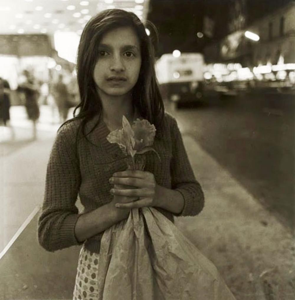 Diane Arbus, Child selling plastic orchids, NYC 1963: Photographer: Diane Arbus )1923 -1971) was an American photographer. Arbus worked to normalize marginalized groups and highlight the importance of proper representation of all people. Title: Child sel