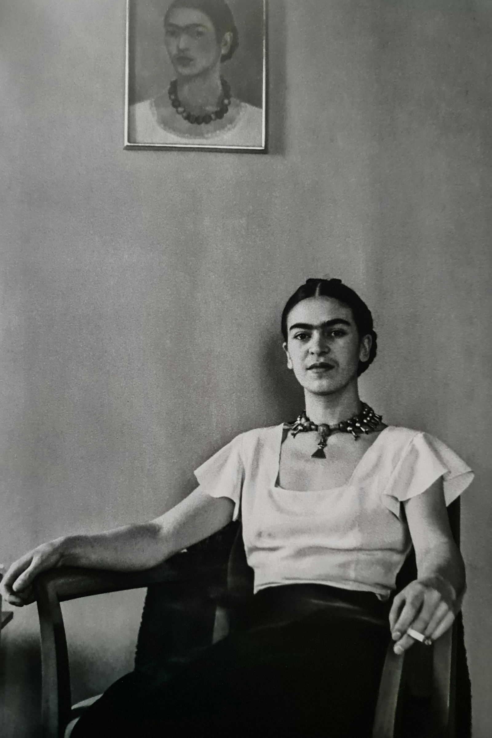 Frida Kahlo, Seated in front of self portrait, 1933: Subject: Seated in front of self portrait Subject/Title- Frida Kahlo Photos Type Of Print: Authentic Vintage Sheet Fed Photogravure/Heliogravure Date Of Print: 2021 Publisher: Taschen GmbH Paper: Medi