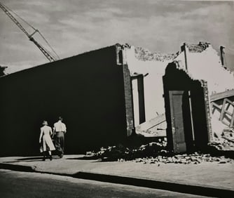 André Kertész, Couple walking by broken building, New York, 1939