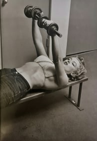 Philippe Halsman, Marilyn Monroe lifting weights with two barbells, 1952