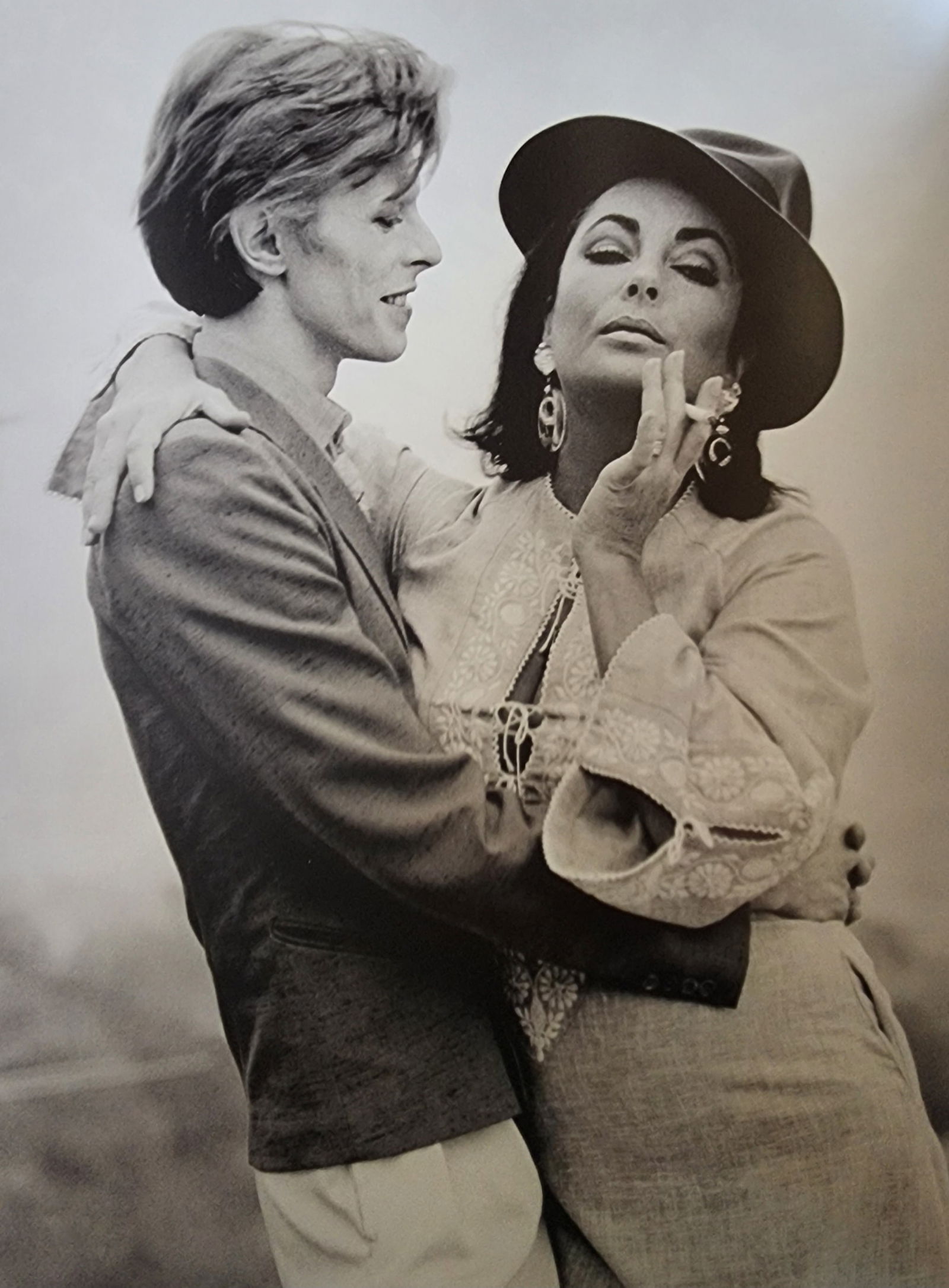 Terry O'Neill, 'David Bowie & Elizabeth Taylor', 1974: Photographer: Terence Patrick O'Neill CBE was a British photographer, known for documenting the fashions, styles, and celebrities of the 1960s. O'Neill's photographs capture his subjects candidly or i