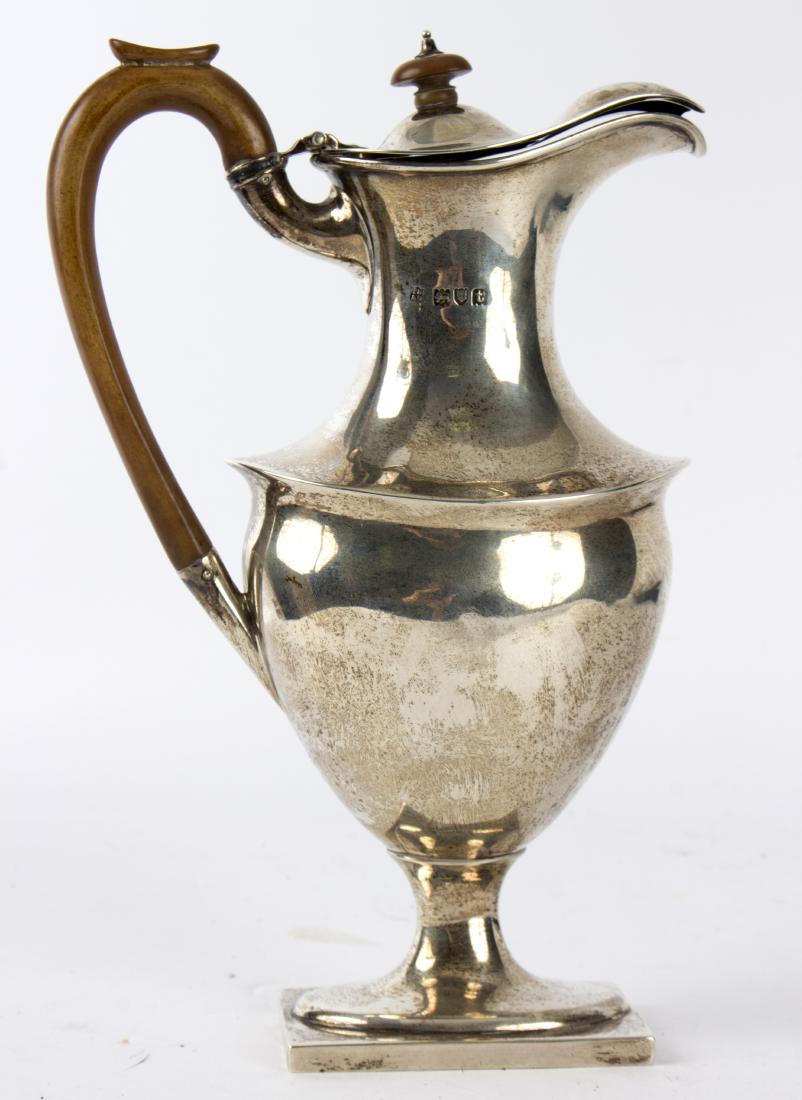 A silver hot water ewer, Thomas Bradbury & Sons.,: A silver hot water ewer, Thomas Bradbury & Sons., London 1914, with oval roundel depicting Hope with her Anchor to one side and fruitwood handle, 23cm high, approximately 395gm gross