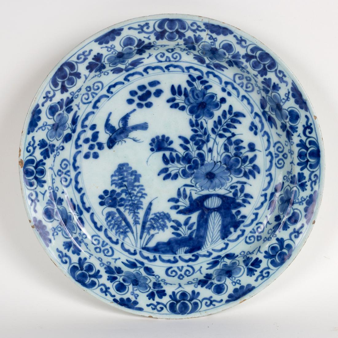 A Dutch delft blue and white plate decorated in (1 of 2)