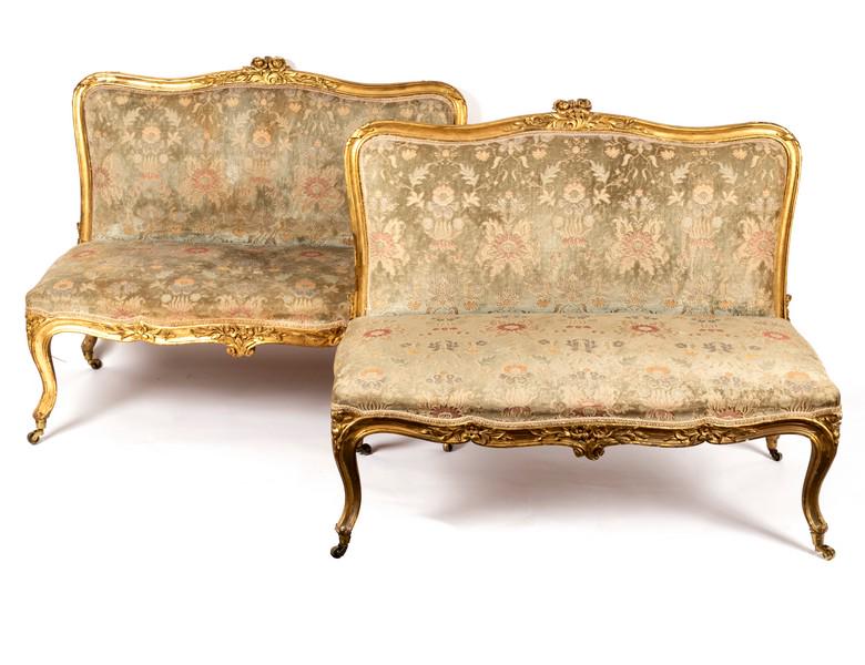 A pair of French 19th Century giltwood framed: A pair of French 19th Century giltwood framed two-seater settees, the moulded frames to an upholstered serpentine back and seat on cabriole legs and castors, 114cm wide/Provenance: Phillips 05.02.01 T