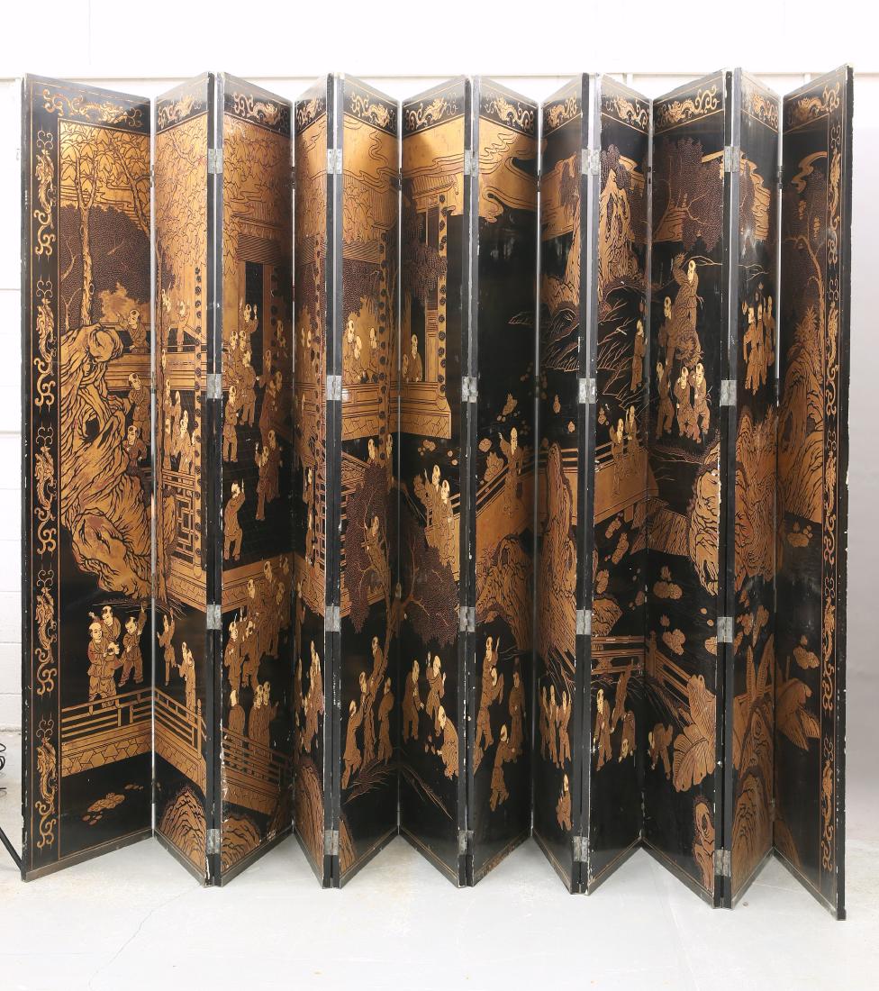 A LARGE CHINESE EXPORT PARCEL-GILT AND LACQUER: A LARGE CHINESE EXPORT PARCEL-GILT AND LACQUER TWELVE-FOLD SCREEN, depicting figures, river landscape and buildings, the reverse with bamboo and foliage. 355cm high, each panel 51cm wide