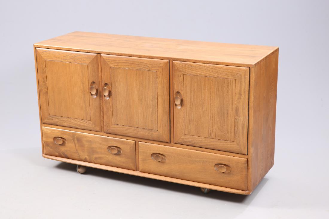 AN ERCOL WINDSOR GOLDEN DAWN DINING ROOM: AN ERCOL WINDSOR GOLDEN DAWN DINING ROOM SUITE, comprising three door sideboard, pedestal extending dining table and four chairs with ladder backs. Table 148cm long (extended), sideboard 129cm long