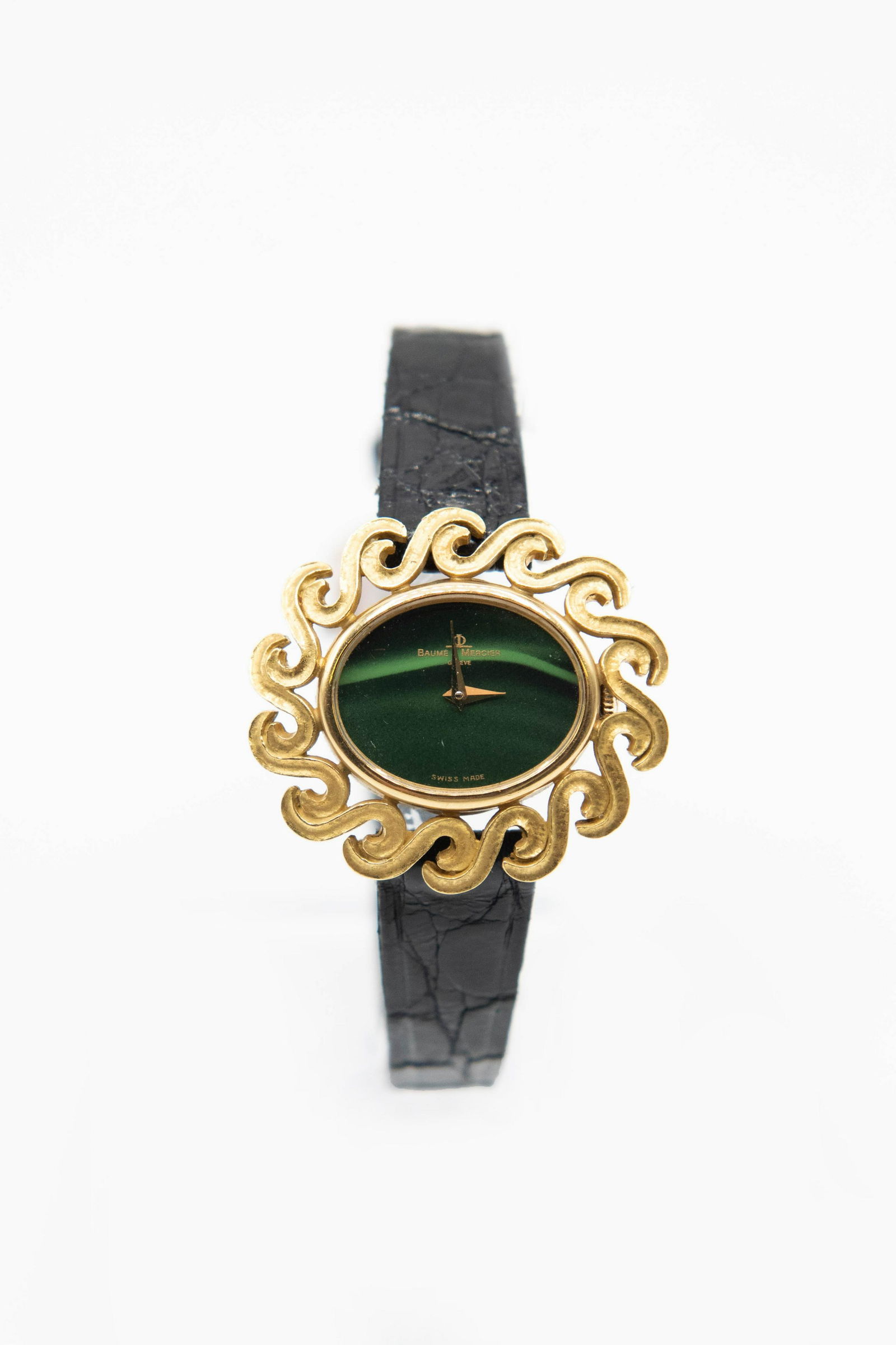 A LADY'S 18CT GOLD BAUME & MERCIER WATCH. Oval striped: A LADY'S 18CT GOLD BAUME & MERCIER WATCH. Oval striped green enamel dial simulating malachite signed Baume & Mercier Geneve Swiss Made, with gilt hands, scroll decoration border applied to outer case