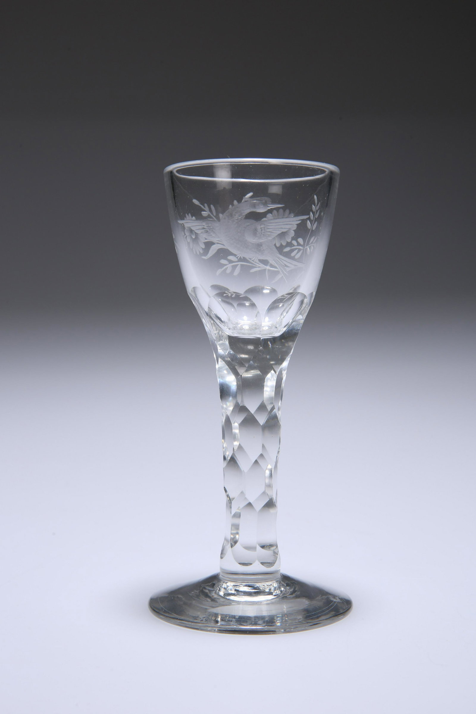 AN 18TH CENTURY ENGRAVED WINE GLASS, the tapering ogee: AN 18TH CENTURY ENGRAVED WINE GLASS, the tapering ogee bowl decorated with an exotic bird and floral spray, on a faceted stem and domed circular foot. 14cm