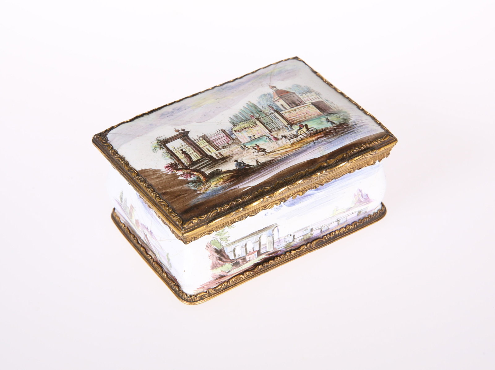 A CONTINENTAL ENAMEL BOX, 18TH CENTURY, of: A CONTINENTAL ENAMEL BOX, 18TH CENTURY, of cushion-shaped rectangular form, the gilt-metal mounts chased with Rococo scrolls, the top and four sides each painted with landscape vignette. 3.4cm high, 7