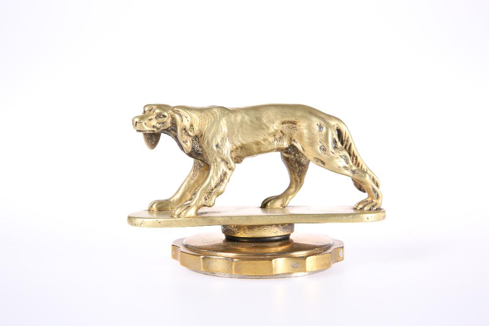 A GILT-METAL CAR MASCOT MODELLED AS A SETTER, probably: A GILT-METAL CAR MASCOT MODELLED AS A SETTER, probably A.E. Lejeune, mounted on a radiator cap. Length 13cm