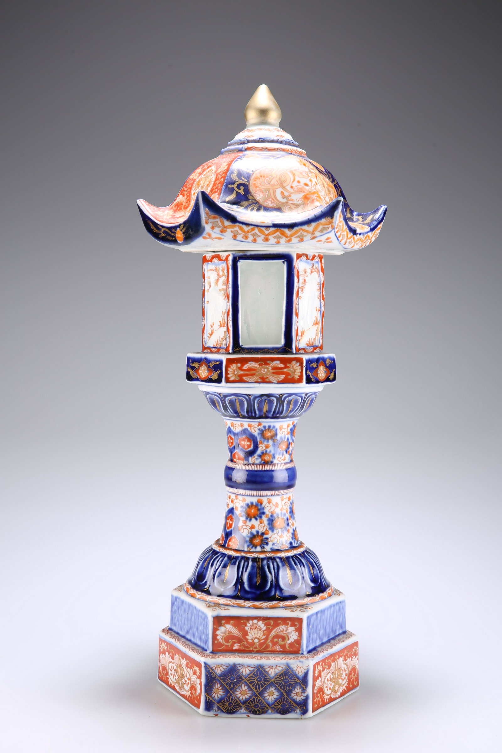 A JAPANESE MEIJI PERIOD IMARI TEMPLE LANTERN, with: A JAPANESE MEIJI PERIOD IMARI TEMPLE LANTERN, with hexagonal base, cylindrical pedestal, and pagoda-style top with onion finial, decorated with cranes and foliage. 42cm high