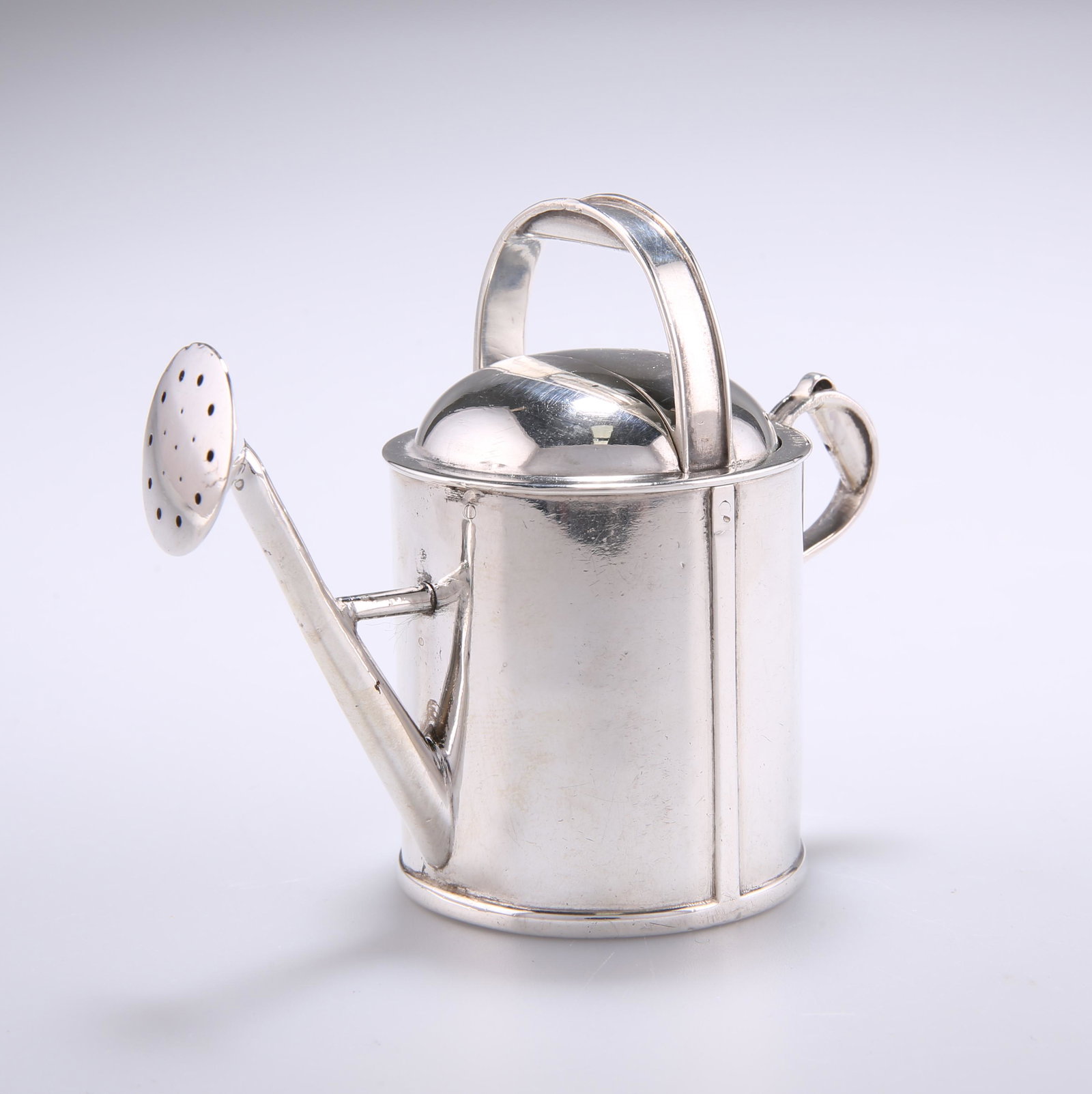 A VICTORIAN NOVELTY SILVER ATOMISER, by Thomas Johnson,: A VICTORIAN NOVELTY SILVER ATOMISER, by Thomas Johnson, London 1879, in the form of a watering can, the handle pushes down to spray, retailed by Jenner & Knewstub, 33 St. James's St. 6.8cm high, 5.2 t