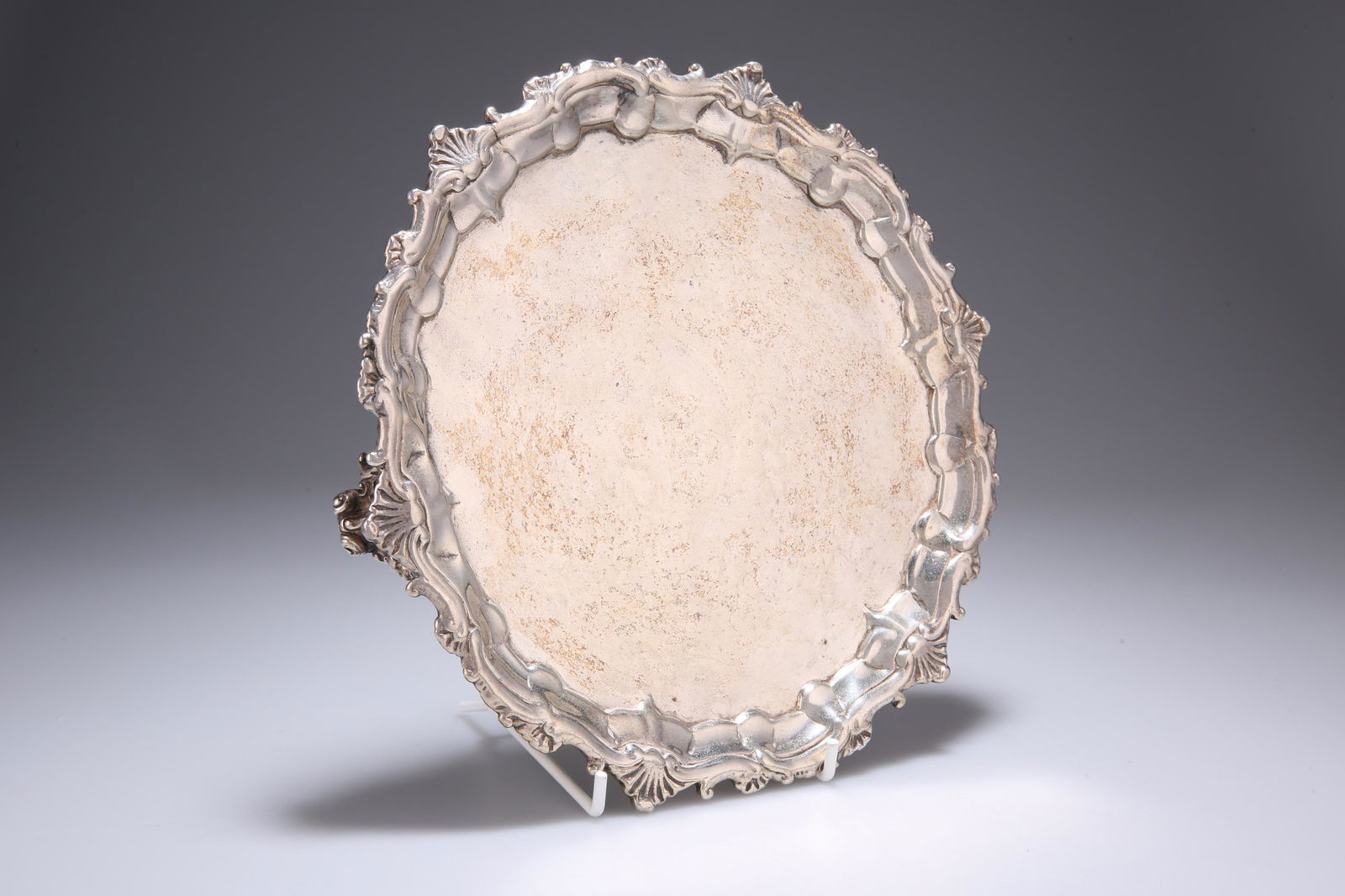 ^ A VICTORIAN SILVER SALVER, maker's mark rubbed,: ^ A VICTORIAN SILVER SALVER, maker's mark rubbed, inscribed 'Hunt & Roskell, Late Storr & Mortimer, 6656', London 1874, circular with shell and scroll cast border, raised on three pierced scroll-cast