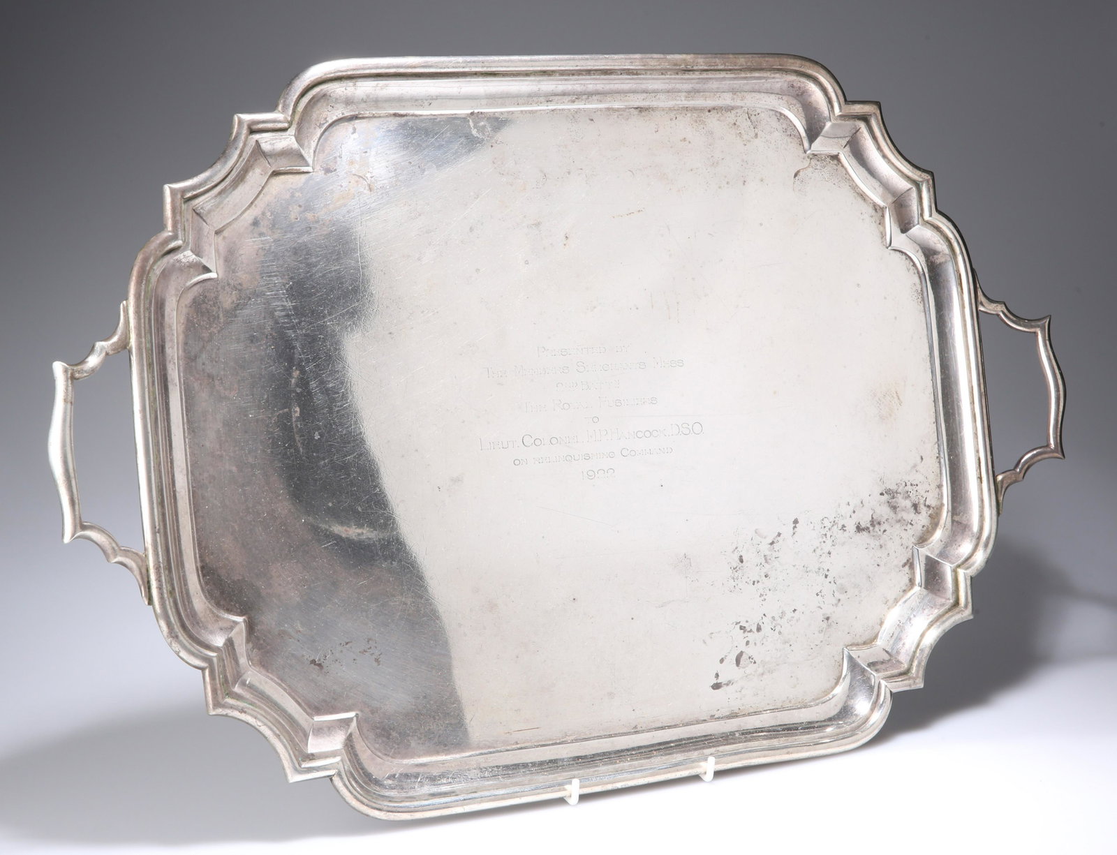 ~ A LARGE GEORGE V SILVER TWO-HANDLED TRAY, by: ~ A LARGE GEORGE V SILVER TWO-HANDLED TRAY, by Goldsmiths & Silversmiths Co Ltd, London 1922, rectangular form with inverted corners, Royal Fusiliers presentation engraving to Lieut. Colonel M.P. Hanc