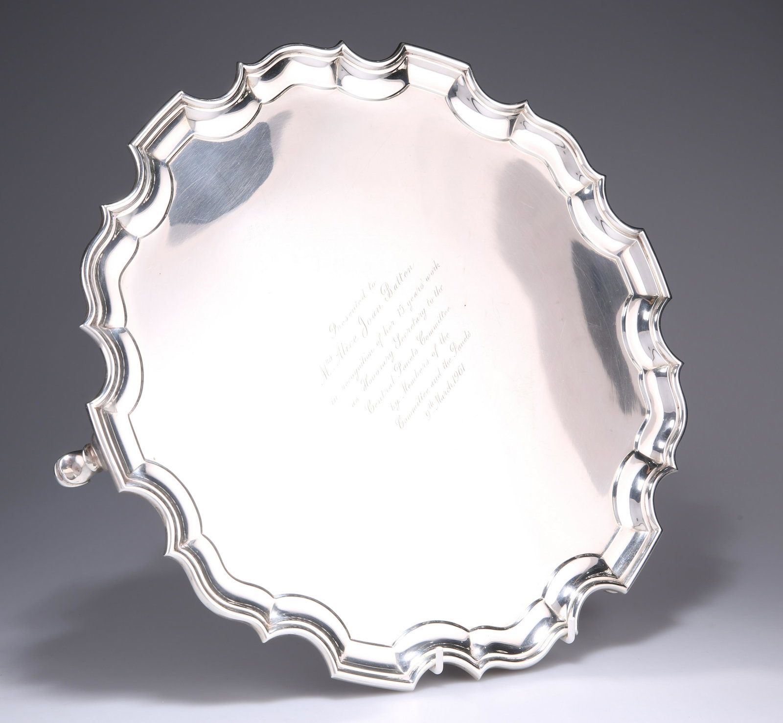 A LARGE GEORGE VI SILVER SALVER, by Richard Comyns,: A LARGE GEORGE VI SILVER SALVER, by Richard Comyns, London 1937, with piecrust edge, raised on three C-scroll and pad feet, presentation engraving dated 1961. 36cm diameter, 41.7 troy ounces