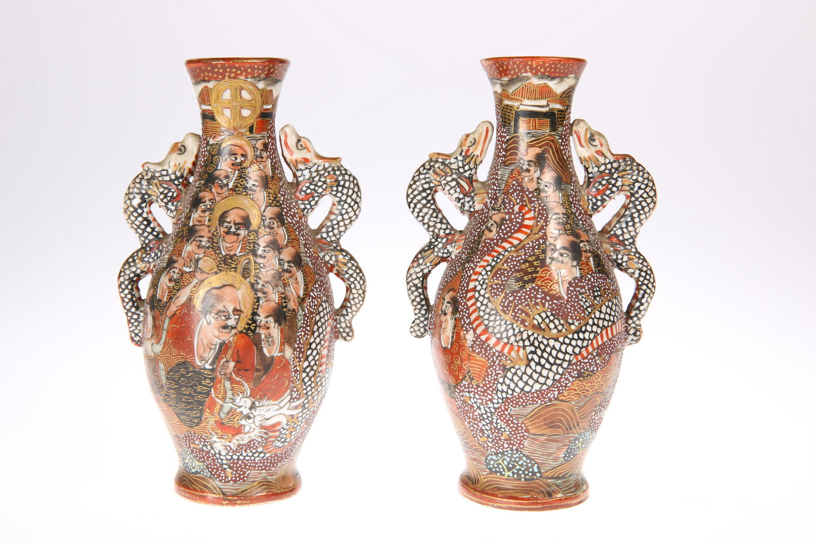 A PAIR OF JAPANESE SATSUMA VASES, MEIJI PERIOD, CIRCA: A PAIR OF JAPANESE SATSUMA VASES, MEIJI PERIOD, CIRCA 1900, of ovoid form with serpent handles, painted with figures and a dragon, signed to iron red reserve. 14.5cm high