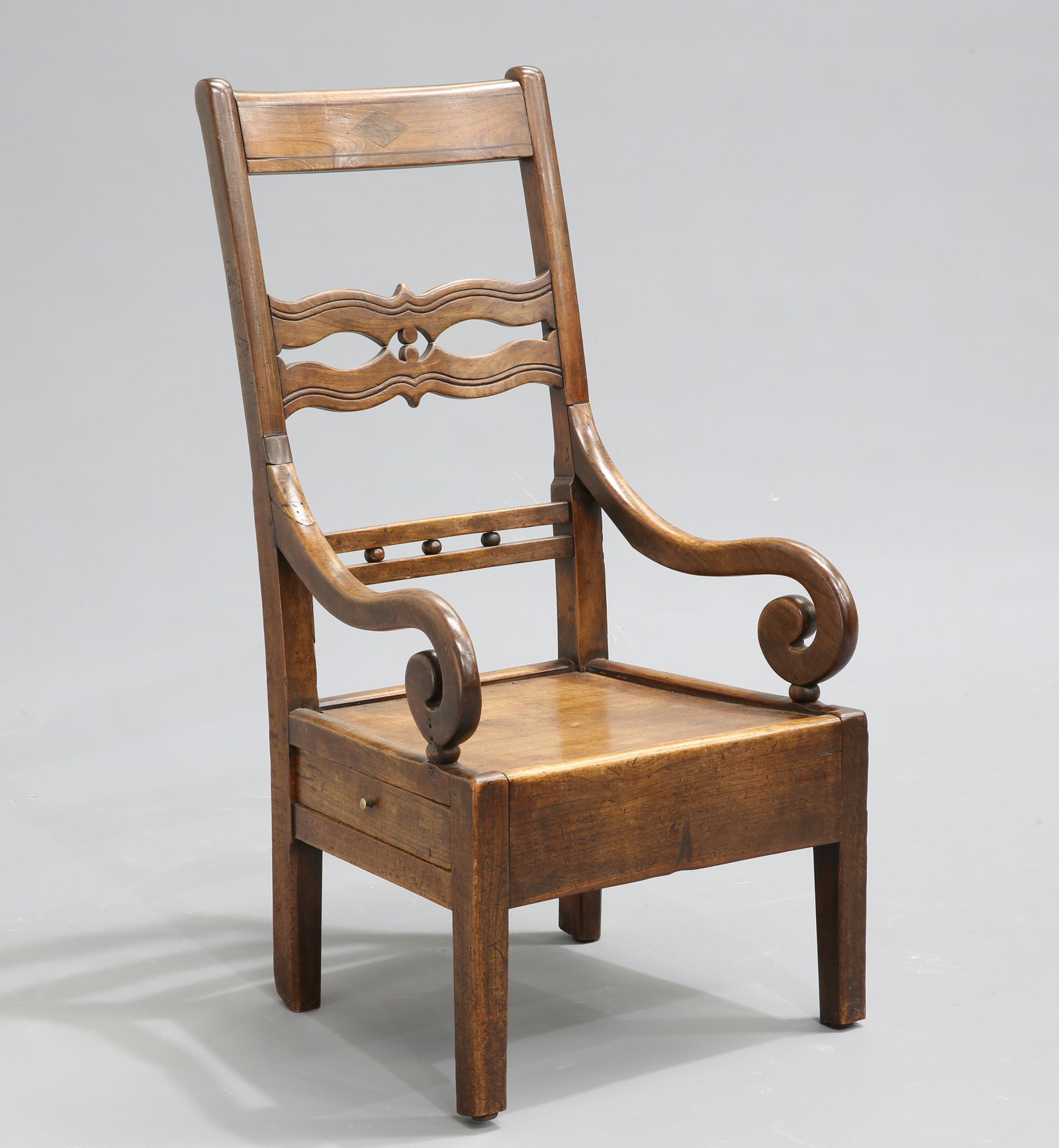 AN EARLY 19TH CENTURY ELM LAMBING CHAIR, with openwork: AN EARLY 19TH CENTURY ELM LAMBING CHAIR, with openwork splat and scrolling arms above a side drawer, raised on square-section legs.