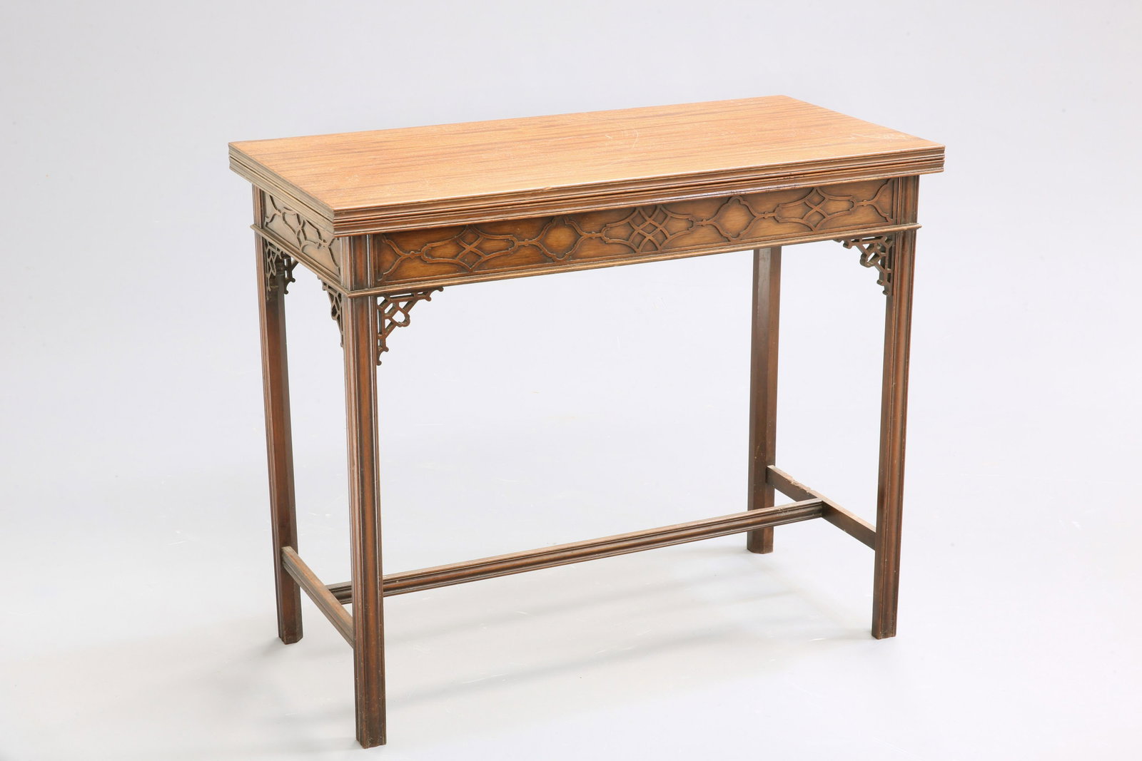 A CHINESE CHIPPENDALE STYLE MAHOGANY FOLDOVER CARD: A CHINESE CHIPPENDALE STYLE MAHOGANY FOLDOVER CARD TABLE, C.1900, the top with moulded edge opening to reveal a tooled leather playing surface above a blind-fretwork carved frieze, raised on moulded s