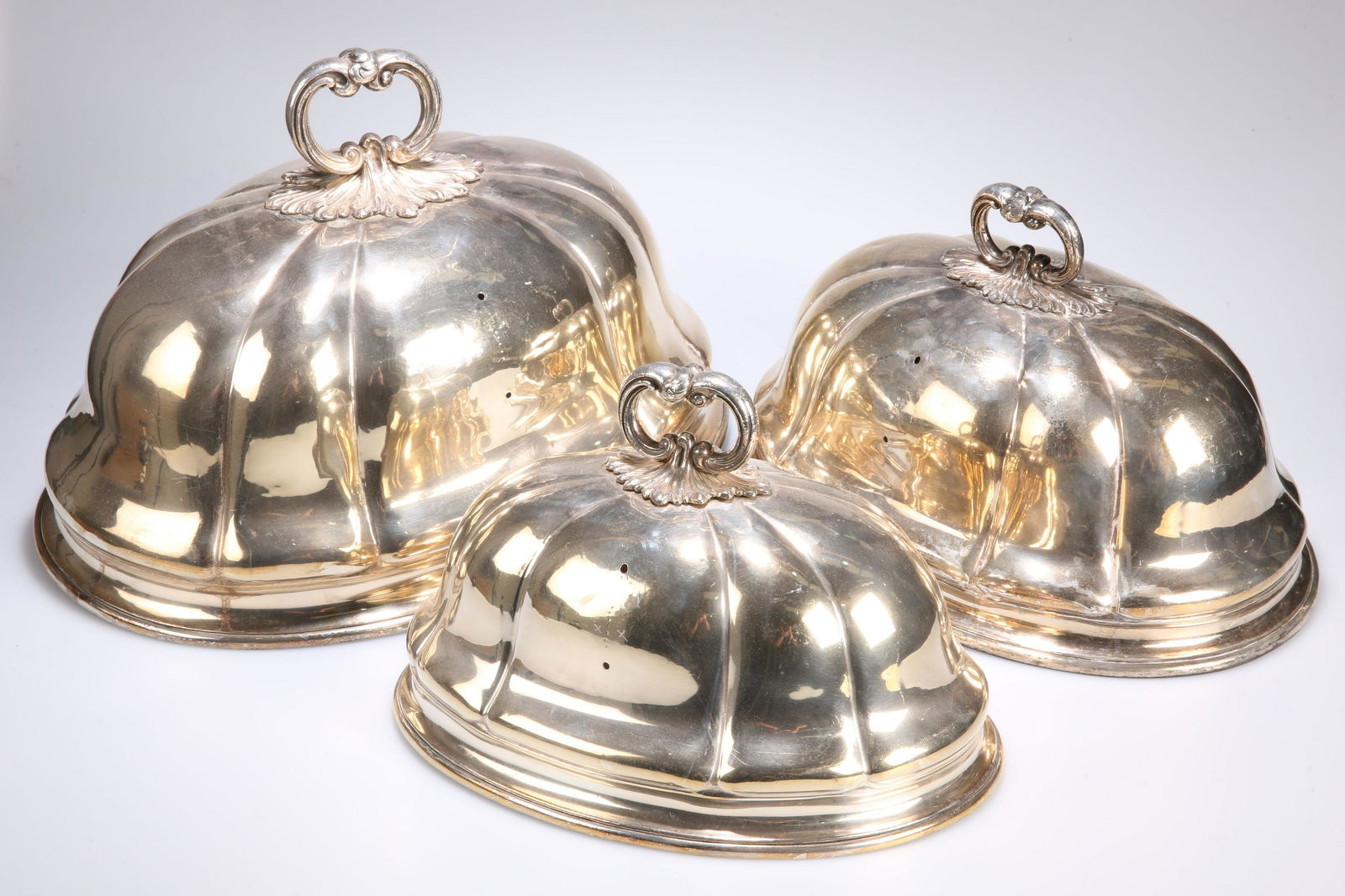^ A GRADUATED SET OF THREE SILVER-PLATED MEAT COVERS, (1 of 1)