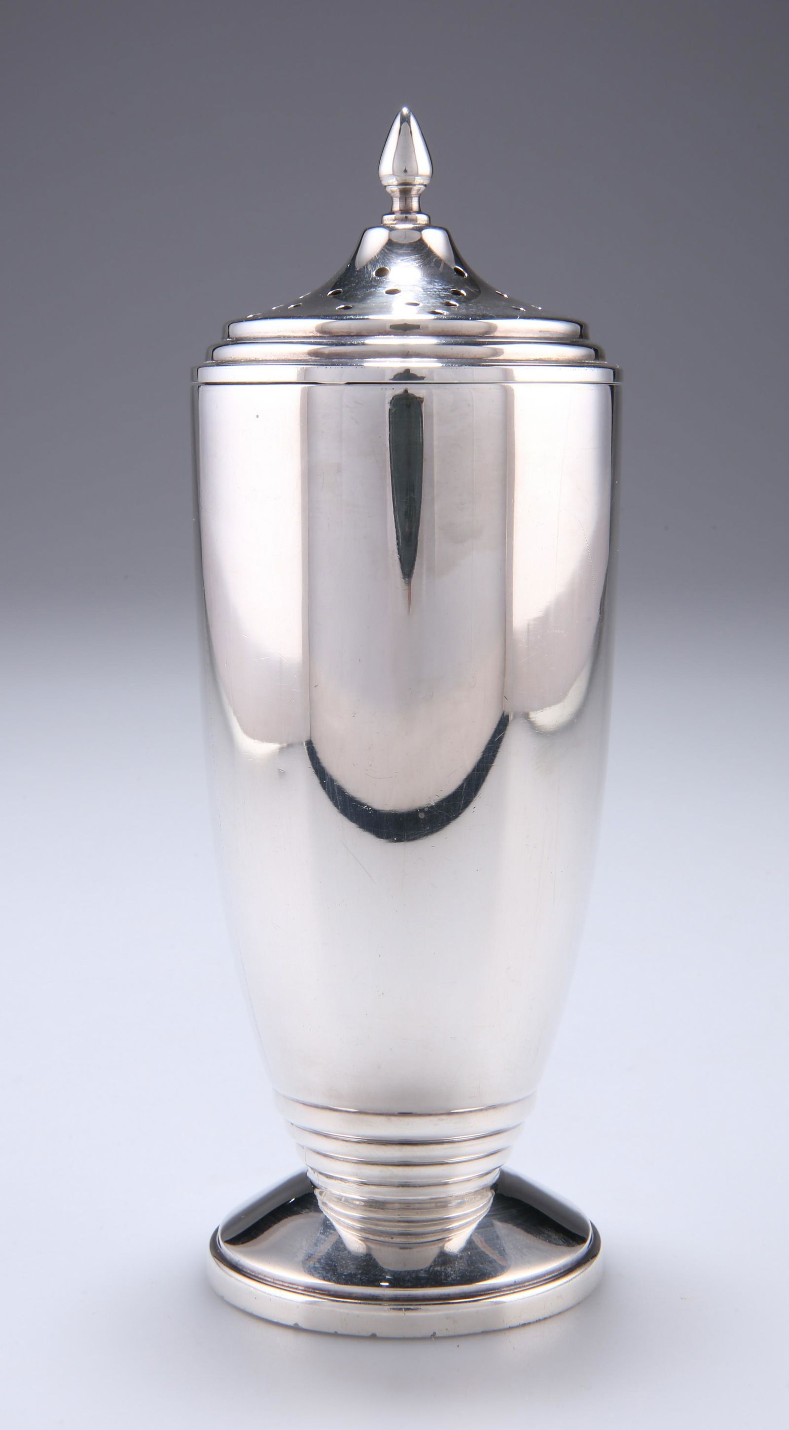 AN ART DECO SILVER SUGAR CASTER, by Sanders &: AN ART DECO SILVER SUGAR CASTER, by Sanders & Mackenzie, Birmingham 1938, of tapering form with stepped detail, the pierced lid with finial, on a circular base. 16.5cm, 4.95 troy ounces.