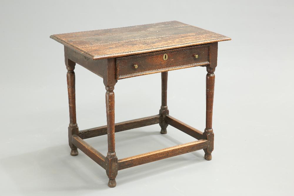 A 17TH CENTURY OAK SIDE TABLE, the moulded rectangular: A 17TH CENTURY OAK SIDE TABLE, the moulded rectangular top over a frieze drawer with moulded edge, raised on baluster legs terminating in blocks joined by stretchers. 71.5cm high, 82cm long, 54cm wide