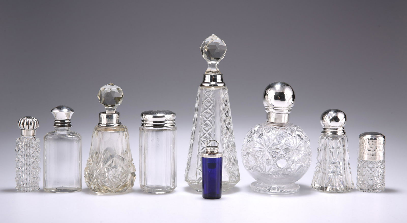 A GROUP OF SIX SILVER-MOUNTED GLASS SCENT BOTTLES AND: A GROUP OF SIX SILVER-MOUNTED GLASS SCENT BOTTLES AND FLASKS, various dates; together with THREE SMALL GLASS BOTTLES, with unmarked mounts. (9) Tallest 16.5cm high