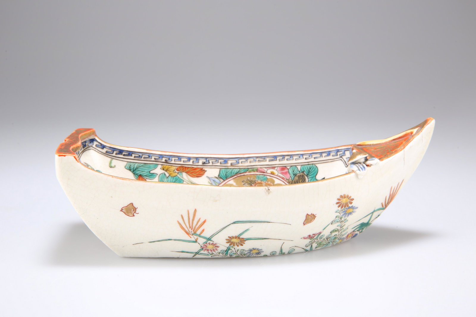 A JAPANESE SATSUMA POTTERY MODEL OF A BOAT, the: A JAPANESE SATSUMA POTTERY MODEL OF A BOAT, the interior painted with reserves of chrysanthemum and peonies amongst red and gilt scrolls and sprays of morning glory, the exterior decorated with furthe