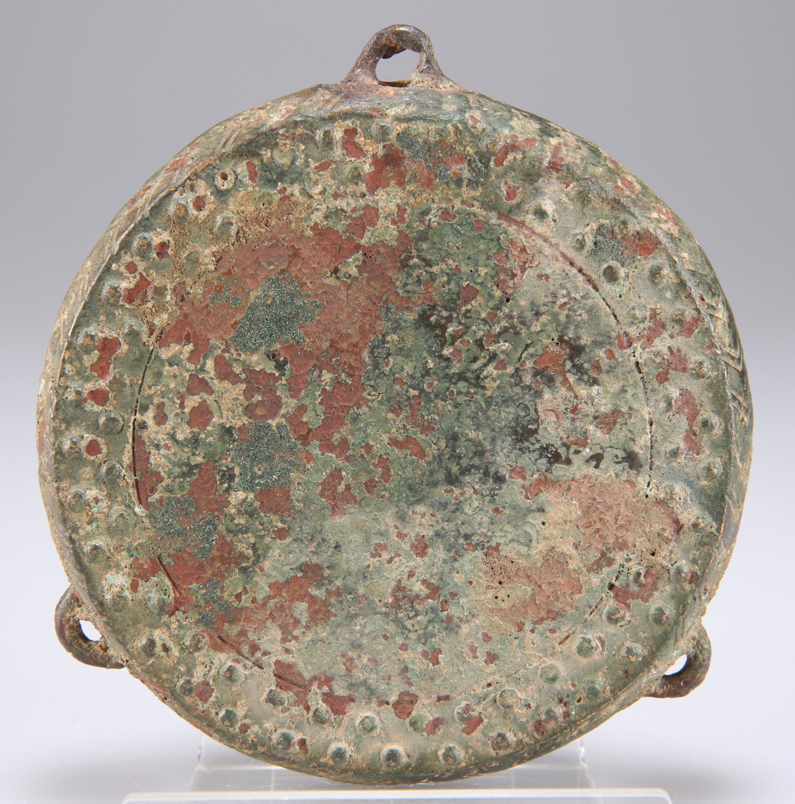 A BRONZE FINIAL OF A DRAGON AND TWO ORNAMENTAL: A BRONZE FINIAL OF A DRAGON AND TWO ORNAMENTAL ROUNDELS, the finial hollow-cast as a powerful elongated dragon head with the open mouth, Eastern Han Dynasty; one roundel with geometric patterns and zo