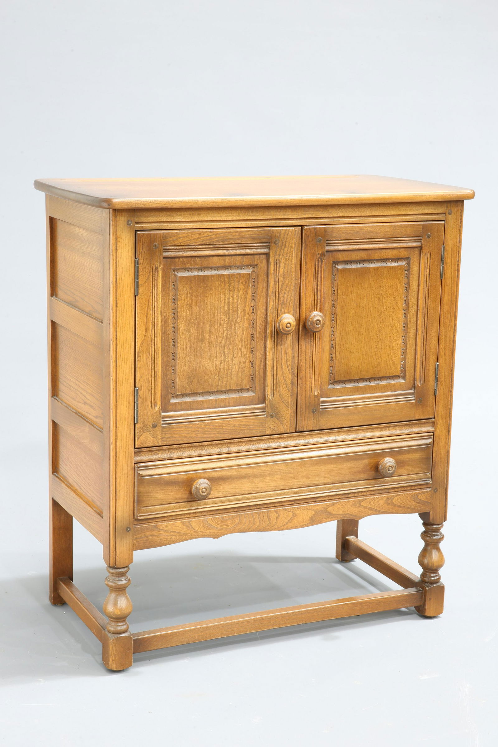 AN ERCOL GOLDEN DAWN SIDE TABLE, fitted with a drawer.: AN ERCOL GOLDEN DAWN SIDE TABLE, fitted with a drawer. 47.5cm wide; together with AN ERCOL GOLDEN DAWN SIDE CABINET, with a pair of cupboard doors over a long drawer, raised on block and baluster legs