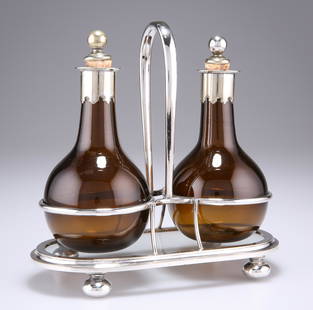 A PAIR OF 19TH CENTURY SILVER-PLATE MOUNTED AMBER GLASS: A PAIR OF 19TH CENTURY SILVER-PLATE MOUNTED AMBER GLASS OIL BOTTLES, on a glass bottomed stand with bun feet. 18.5cm high