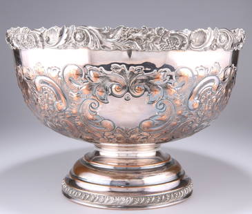 A SILVER-PLATED PUNCH BOWL, circular form with a cast: A SILVER-PLATED PUNCH BOWL, circular form with a cast rim of fruiting vines, shells and foliate scrolls, the body chased with foliate and C-scrolls, with vacant cartouche, raised on a domed circular