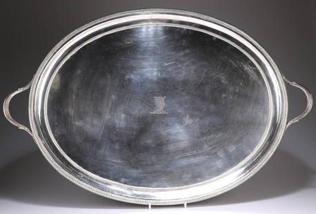 A LARGE OLD SHEFFIELD PLATE TWO-HANDLED TRAY, CIRCA: A LARGE OLD SHEFFIELD PLATE TWO-HANDLED TRAY, CIRCA 1790, oval with bead and reel bands, the reeded handles with leaf-form casting, engraved with a crest. 72cm across handles