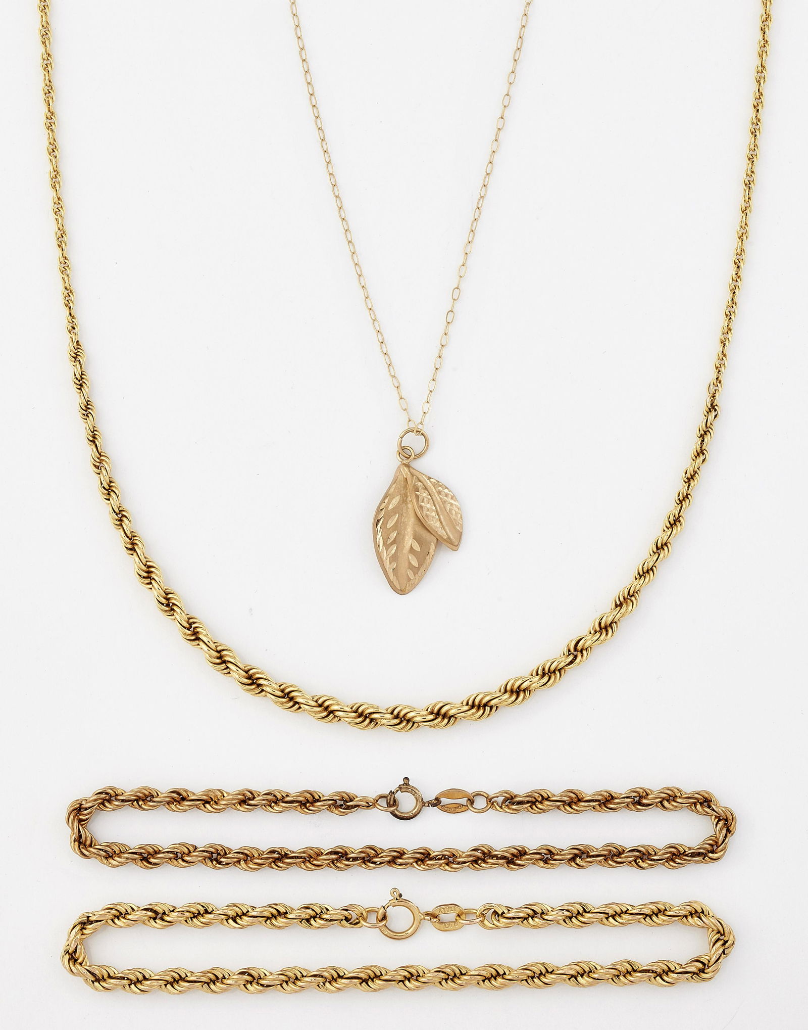 A GROUP OF JEWELLERY, comprising; A 9CT GOLD TAPERING: A GROUP OF JEWELLERY, comprising; A 9CT GOLD TAPERING ROPE CHAIN NECKLACE, length 55.5cm; TWO 9CT GOLD ROPE CHAIN BRACELETS, each 18cm long; AND A LEAF PENDANT ON A FINE TRACE CHAIN, chain length 39.5