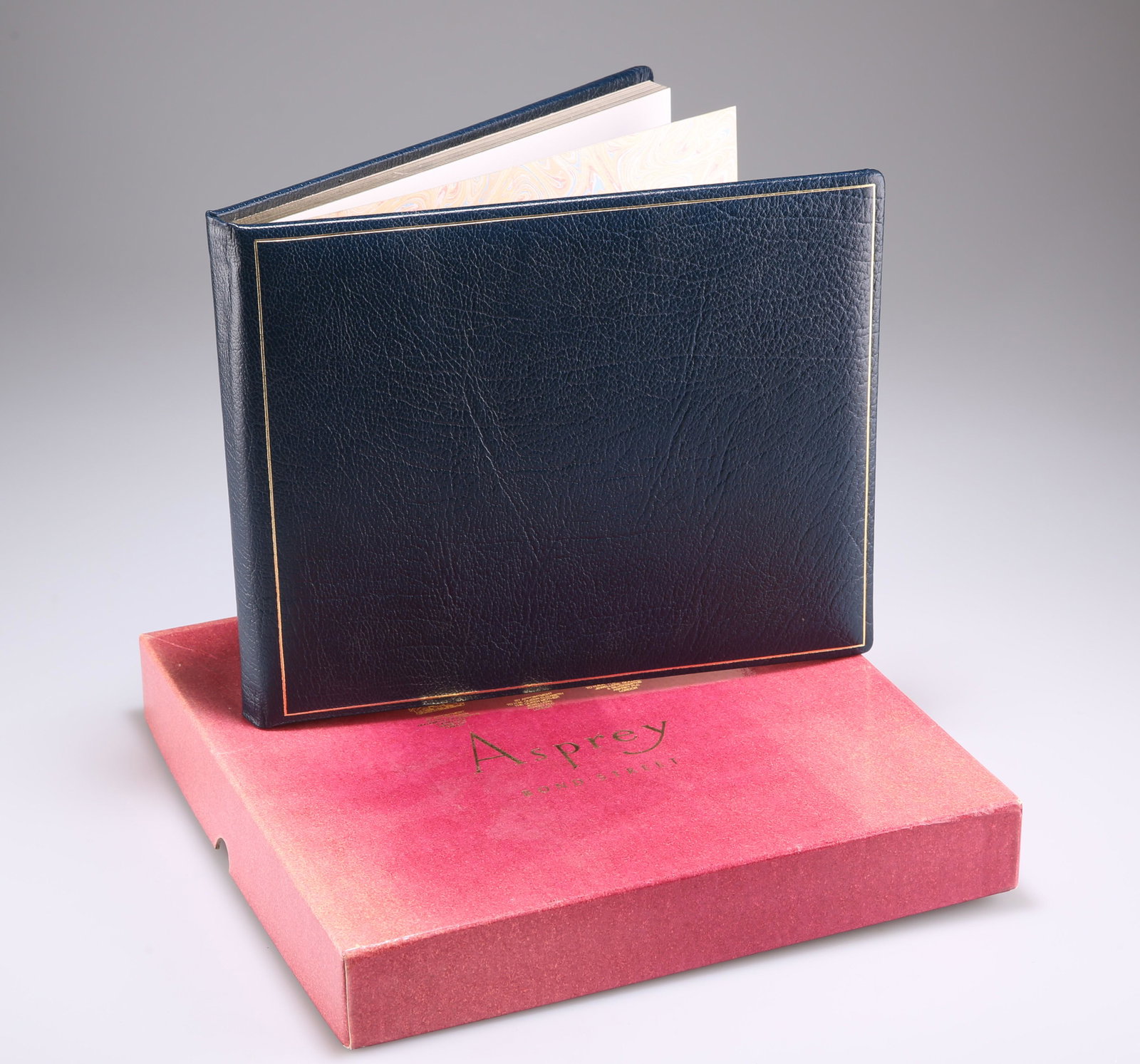 A BLUE AND TOOLED LEATHER BOUND VISITOR BOOK, with gilt: A BLUE AND TOOLED LEATHER BOUND VISITOR BOOK, with gilt edge, in an Asprey box