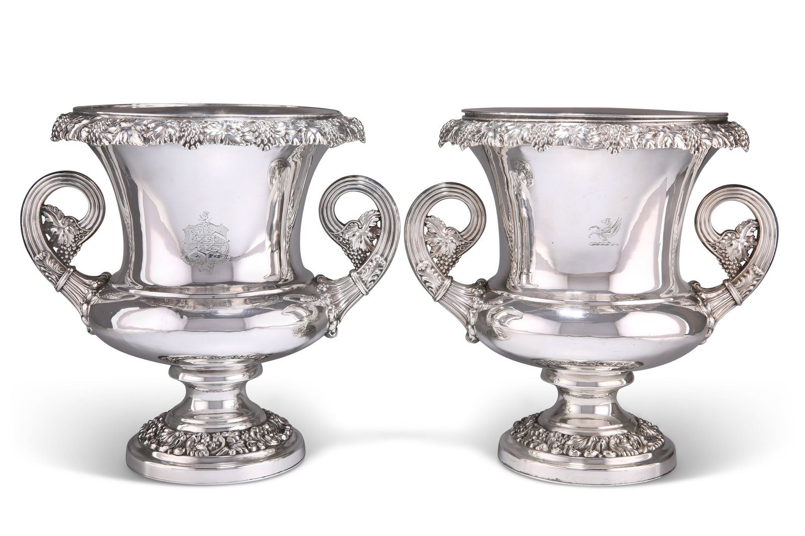 A MATCHED PAIR OF OLD SHEFFIELD PLATE WINE COOLERS,: A MATCHED PAIR OF OLD SHEFFIELD PLATE WINE COOLERS, c.1820, campana form, with collars and liners, with twin reeded scroll handles, the borders cast with fruiting vine, scrolls and foliage, each engra