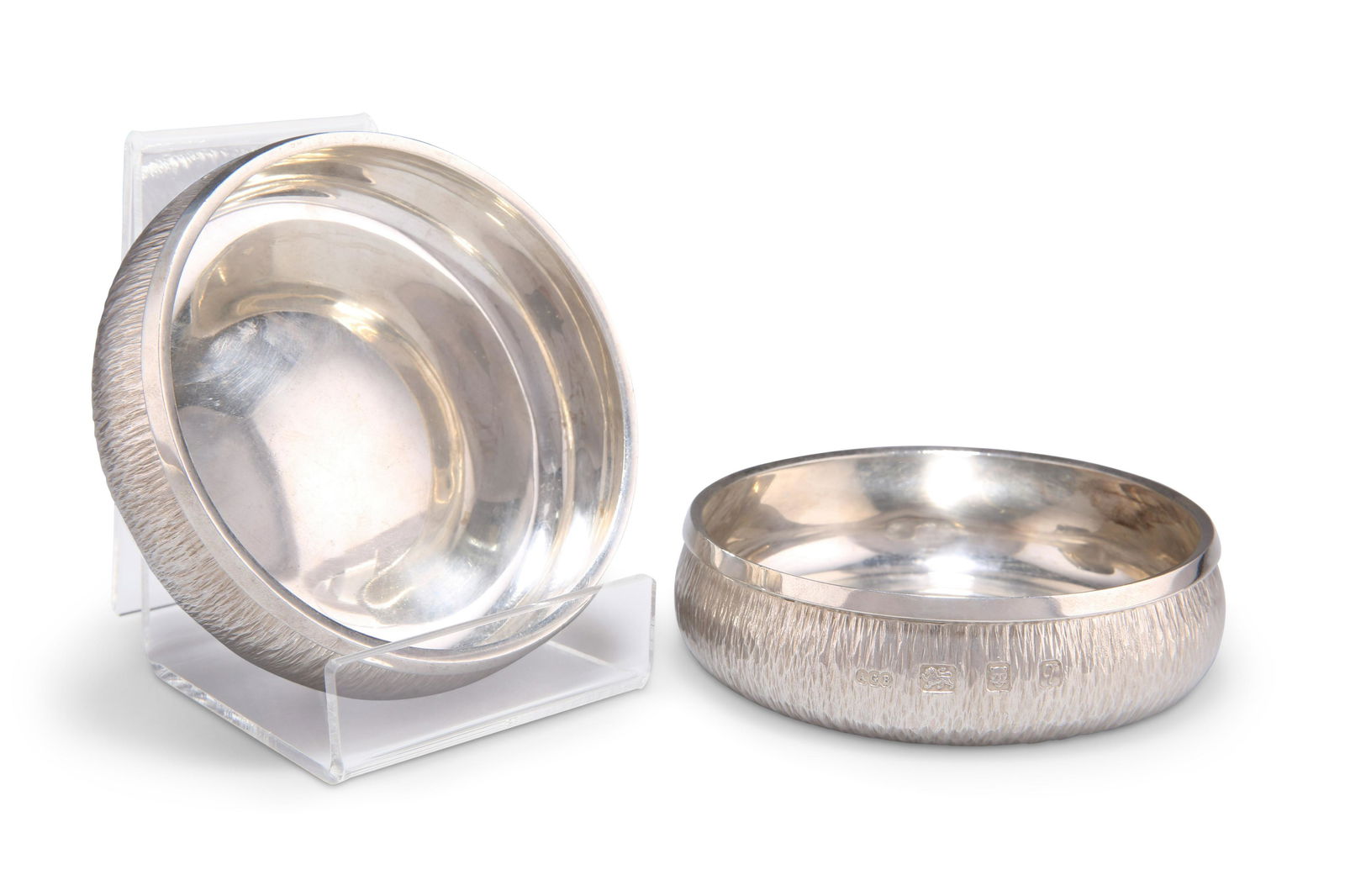 A PAIR OF ELIZABETH II SILVER COASTERS, by Gerald: A PAIR OF ELIZABETH II SILVER COASTERS, by Gerald Benney (1930-2008), London 1971, also stamped 'GERALD BENNEY LONDON', circular, with bark effect textured surface. 10cm diameter, 10.3 troy ouncesGERA