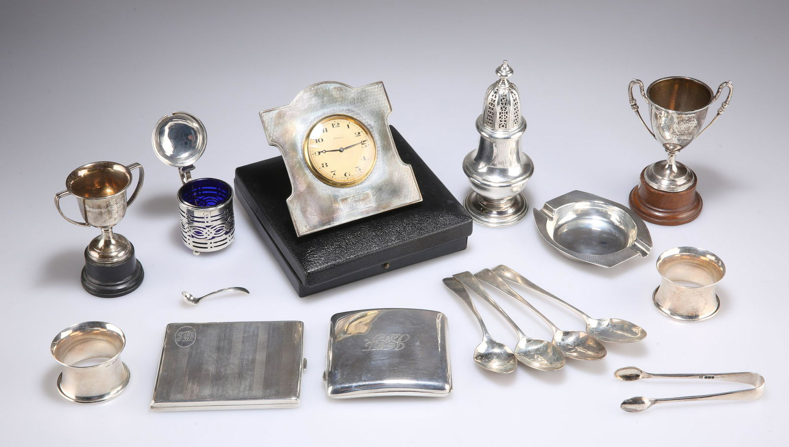 A COLLECTION OF SILVER, including a George V strut: A COLLECTION OF SILVER, including a George V strut clock, by A Buckley Ltd, Birmingham 1923, cased; two cigarette cases; a heavy sugar caster, by Richard Comyns, London 1962; etc. 21.8 troy ounces