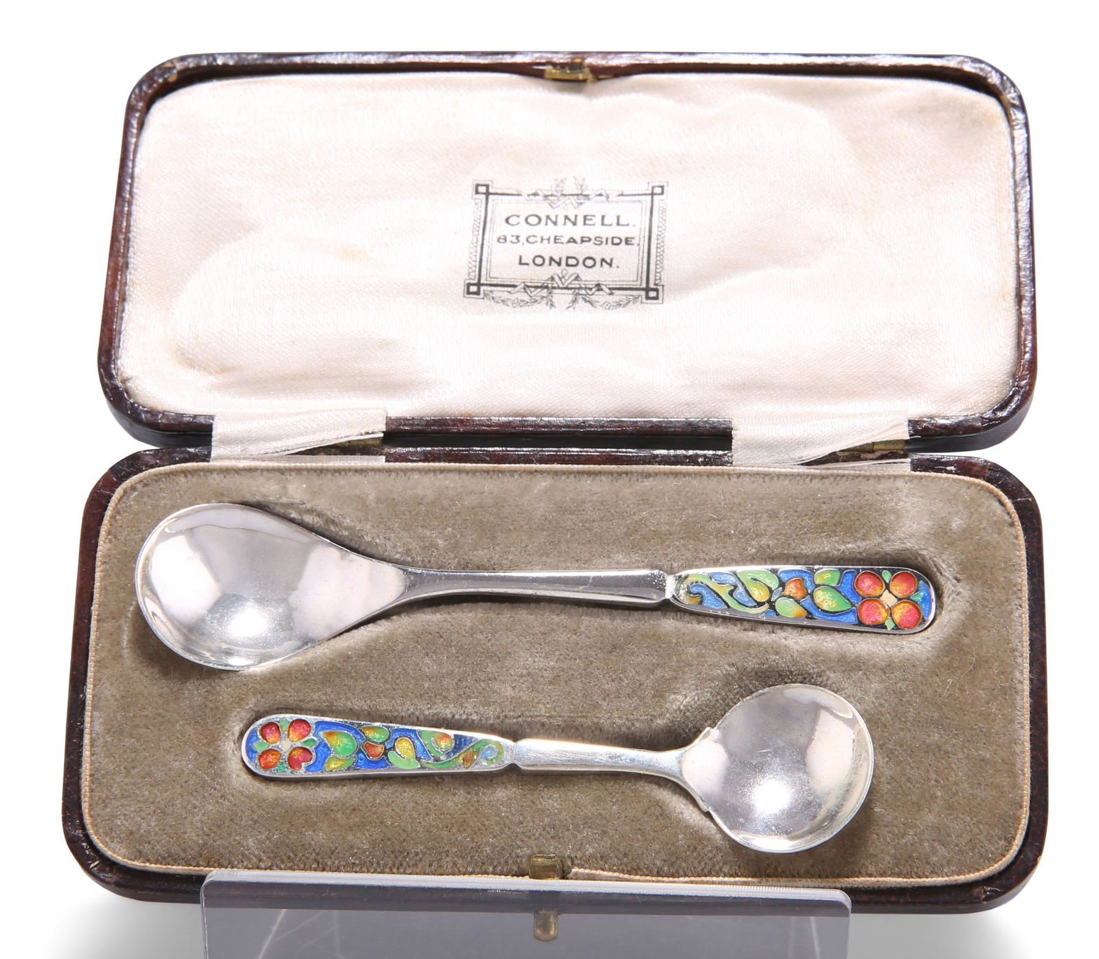 A SET OF TWO GEORGE V SILVER CONDIMENT SPOONS, by: A SET OF TWO GEORGE V SILVER CONDIMENT SPOONS, by Bernard Instone, Birmingham 1928, in Arts and Crafts style, with polychrome floral enamelled handles, the back of each bowl spot-hammered, cased. L