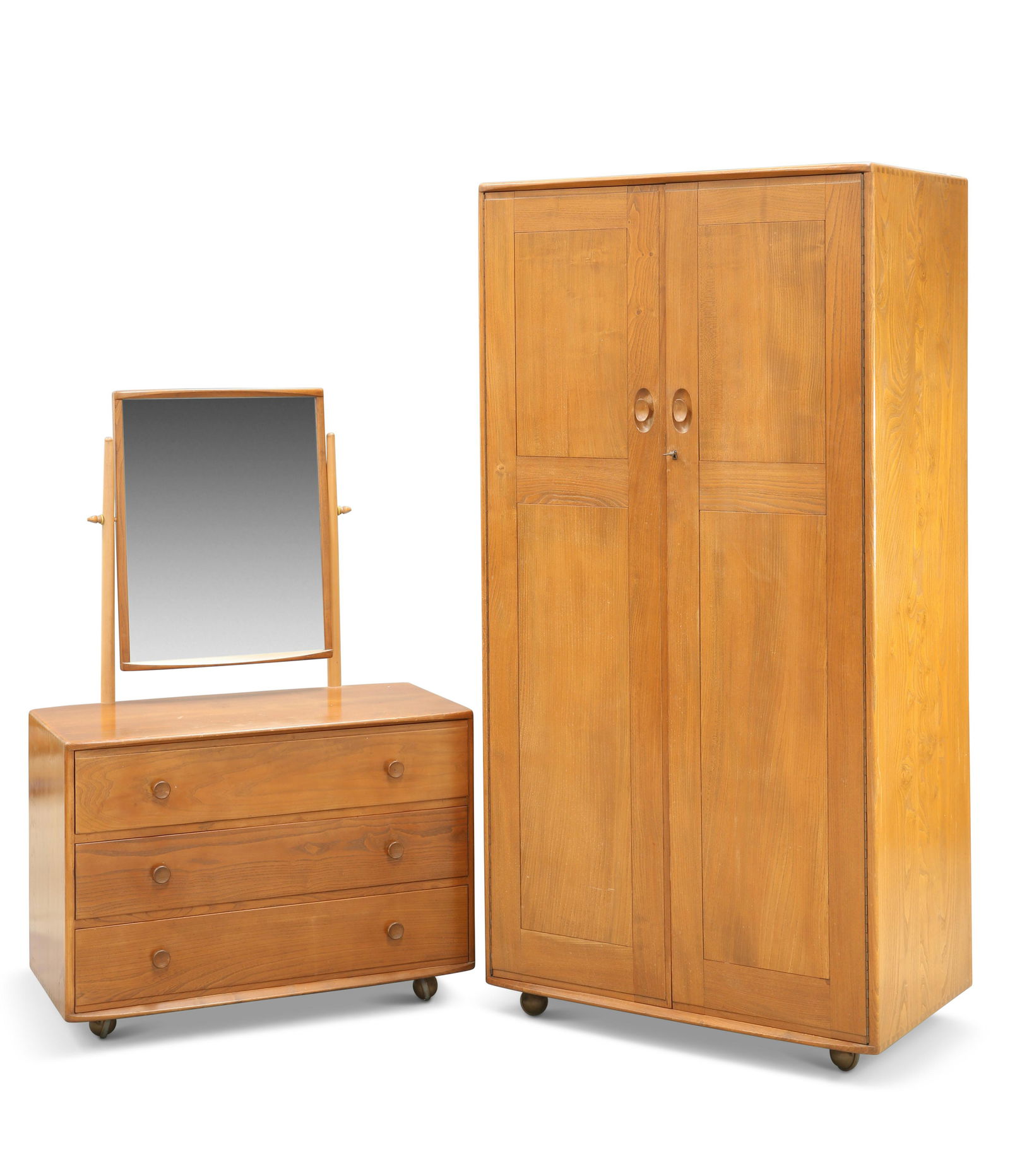 A VINTAGE ERCOL TWO-DOOR WARDROBE AND DRESSING CHEST,: A VINTAGE ERCOL TWO-DOOR WARDROBE AND DRESSING CHEST, the wardrobe with recessed handles, the three-drawer dressing chest with mirrored superstructure, each moving on castors. (2) Wardrobe 183cm high,