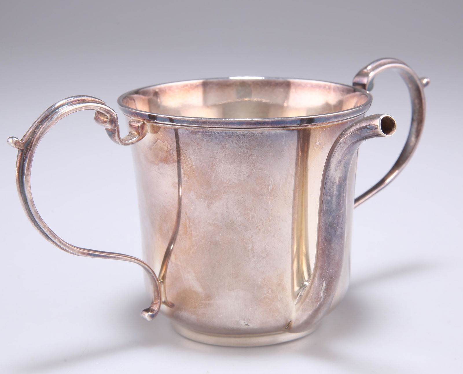 A GEORGE IV SILVER INVALID FEEDING BOAT, by Thomas: A GEORGE IV SILVER INVALID FEEDING BOAT, by Thomas Johnson, London 1824, the cylindrical cup with twin S-scroll handles and tall spout. 8.5cm high, 5.5 troy ounces