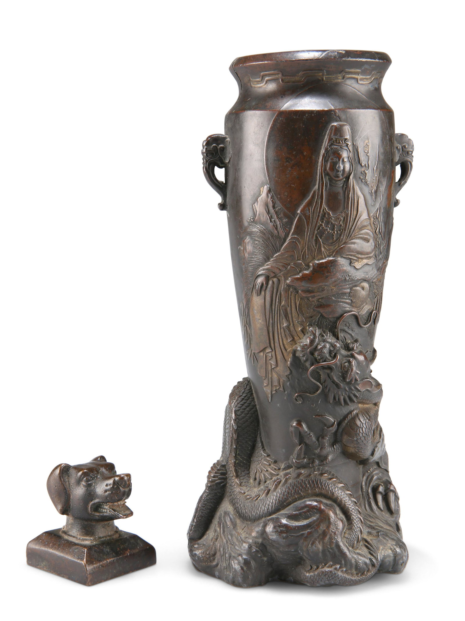 A JAPANESE MEIJI PERIOD BRONZE VASE, amphora form with: A JAPANESE MEIJI PERIOD BRONZE VASE, amphora form with elephant mask handles and decorated depicting Kannon and a figure with a phoenix, the base with a coiled three-toed dragon, 18cm high; and A CHIN