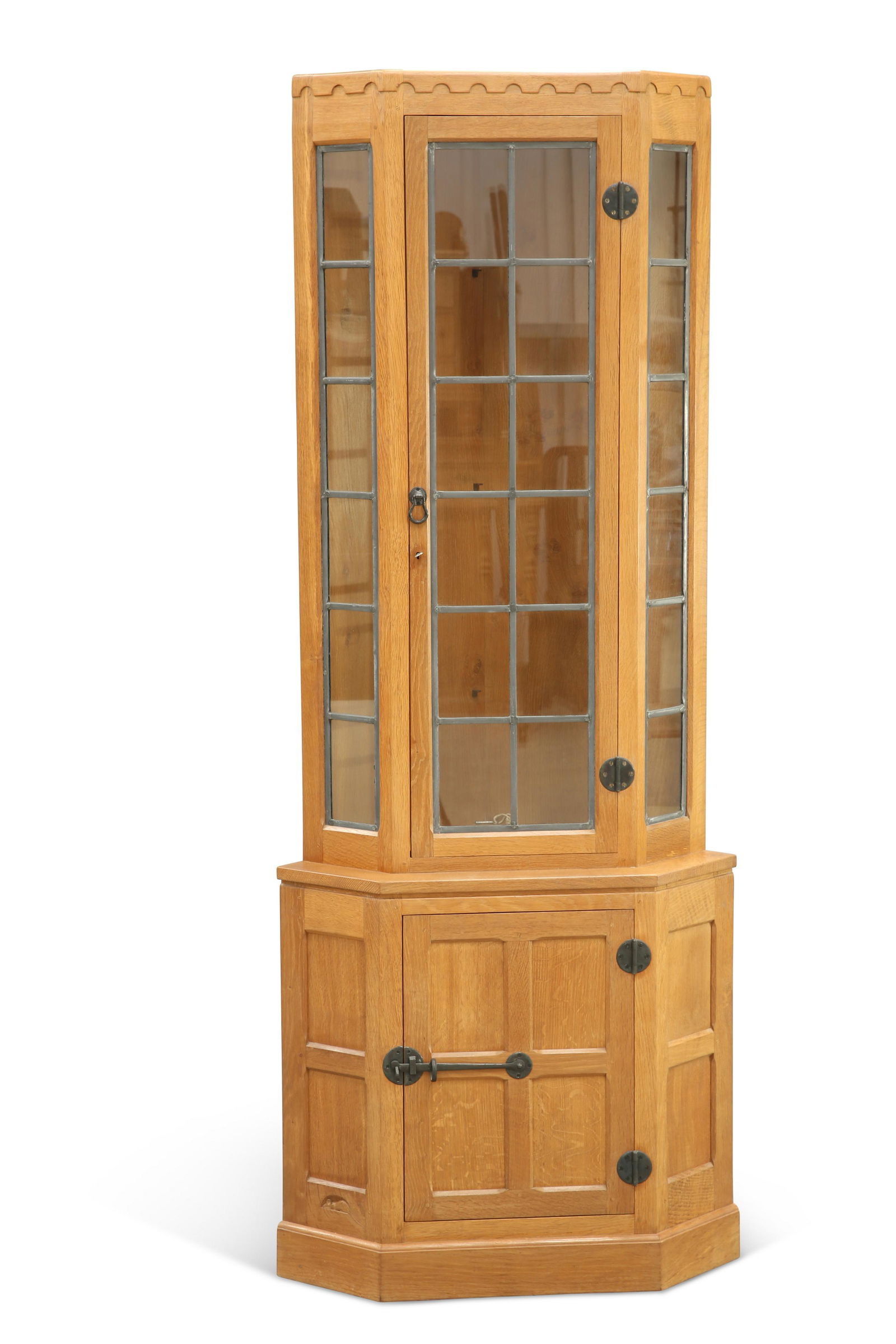 ROBERT THOMPSON OF KILBURN, A MOUSEMAN OAK: ROBERT THOMPSON OF KILBURN, A MOUSEMAN OAK FLOOR-STANDING CORNER CABINET, circa 1970s, with lead glazed upper section above a panelled base with cupboard door, fitted with Arts and Crafts-style iron h
