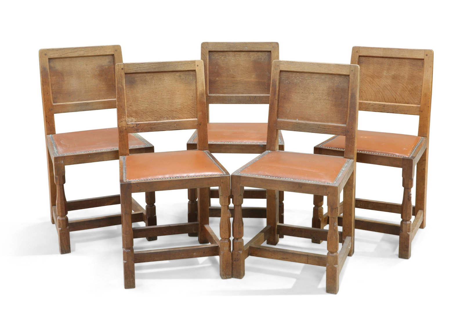 ROBERT THOMPSON OF KILBURN, A SET OF FIVE MOUSEMAN OAK: ROBERT THOMPSON OF KILBURN, A SET OF FIVE MOUSEMAN OAK DINING CHAIRS, each with adzed panel back and faceted baluster legs terminating in blocks joined by stretchers, with carved mouse signature. (5)