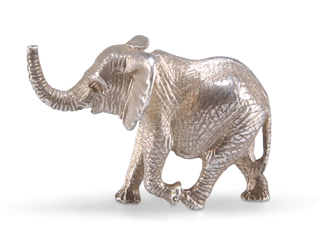A STERLING SILVER ELEPHANT, by Patrick Mavros,: A STERLING SILVER ELEPHANT, by Patrick Mavros, Zimbabwe, modern, the miniature model realistically cast running with trunk raised. 2.1cm long